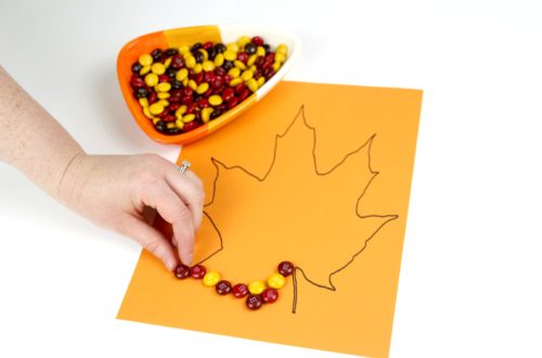 Make an easy fall leaf craft for kids with some colored cardstock and fall-colored candies. Click here to see all the details.