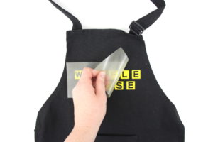 Make a DIY Waffle House Costume with yellow heat transfer vinyl and a blank apron. Click here to see the supply list and the whole tutorial.